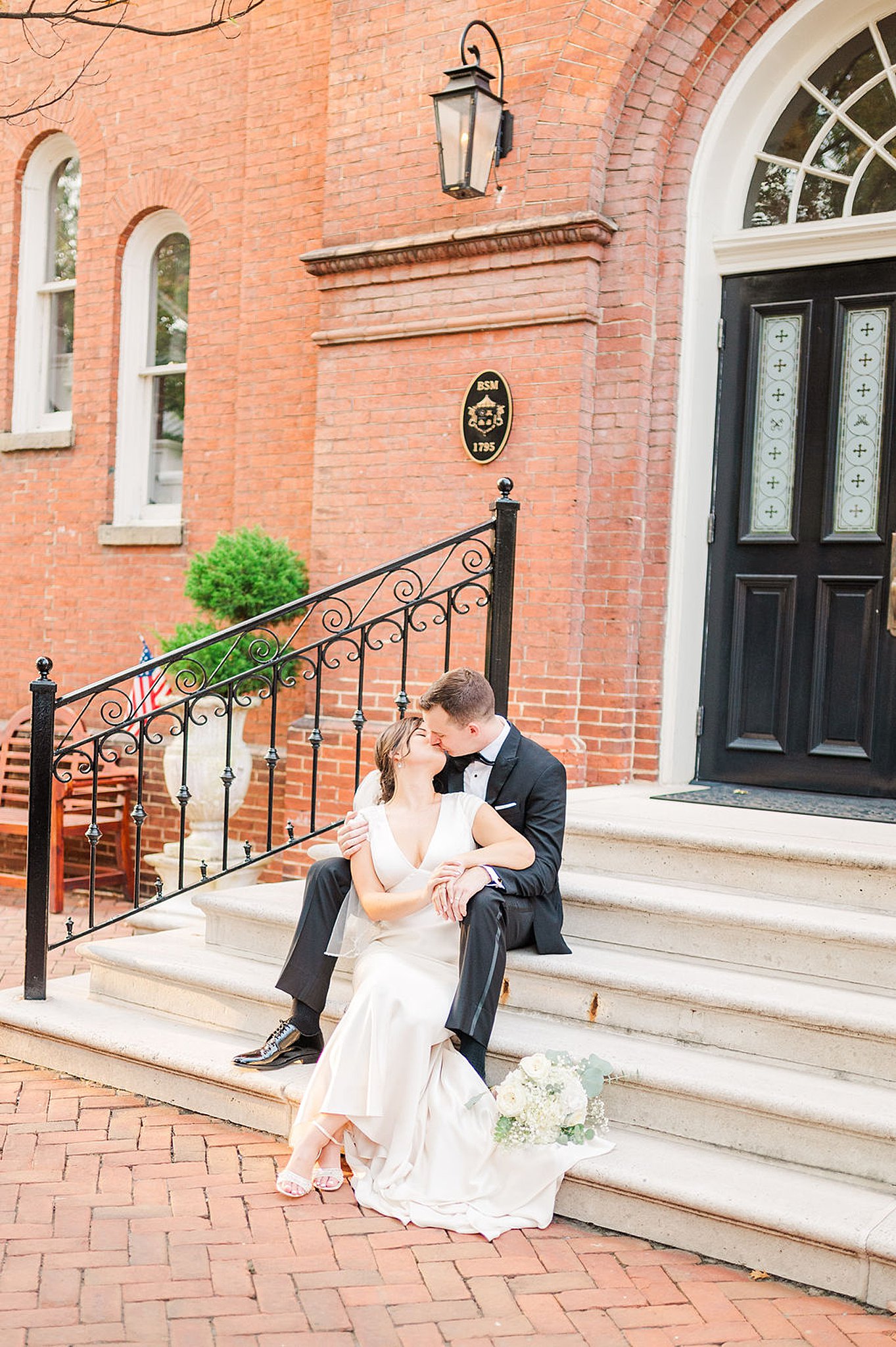 bride and groom sharing a kiss on the stairs at their old town alexandria wedding