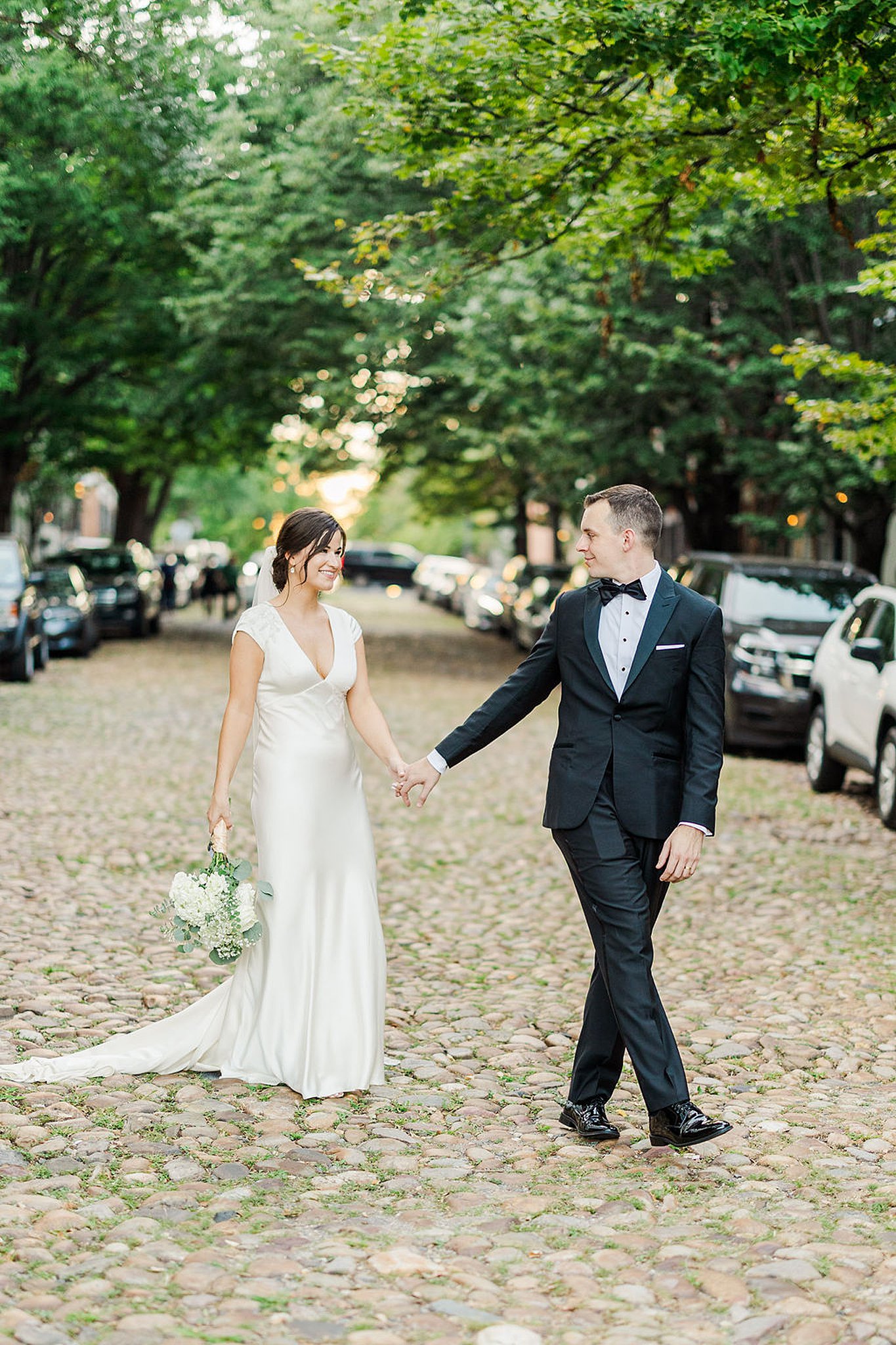 bride and groom walking through the streets during their old town alexandria wedding