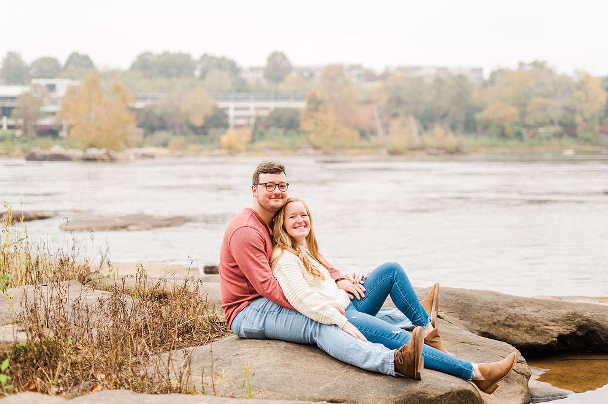 couple sitting with each other on a rock at brown's island Engagement Photos Richmond VA