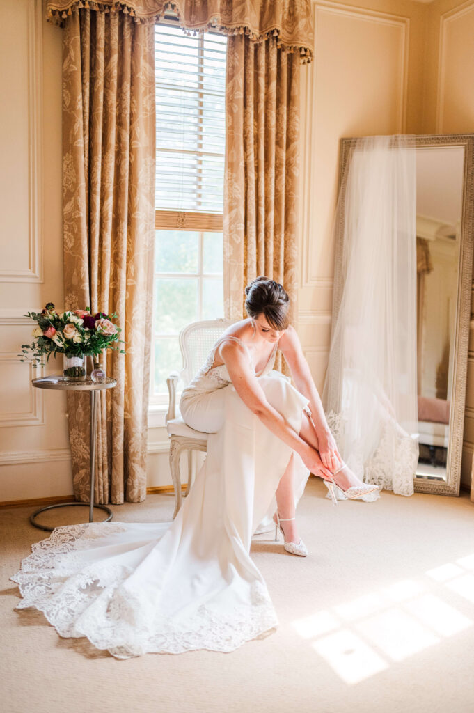 Bride putting on shoes at Great Marsh Estate
