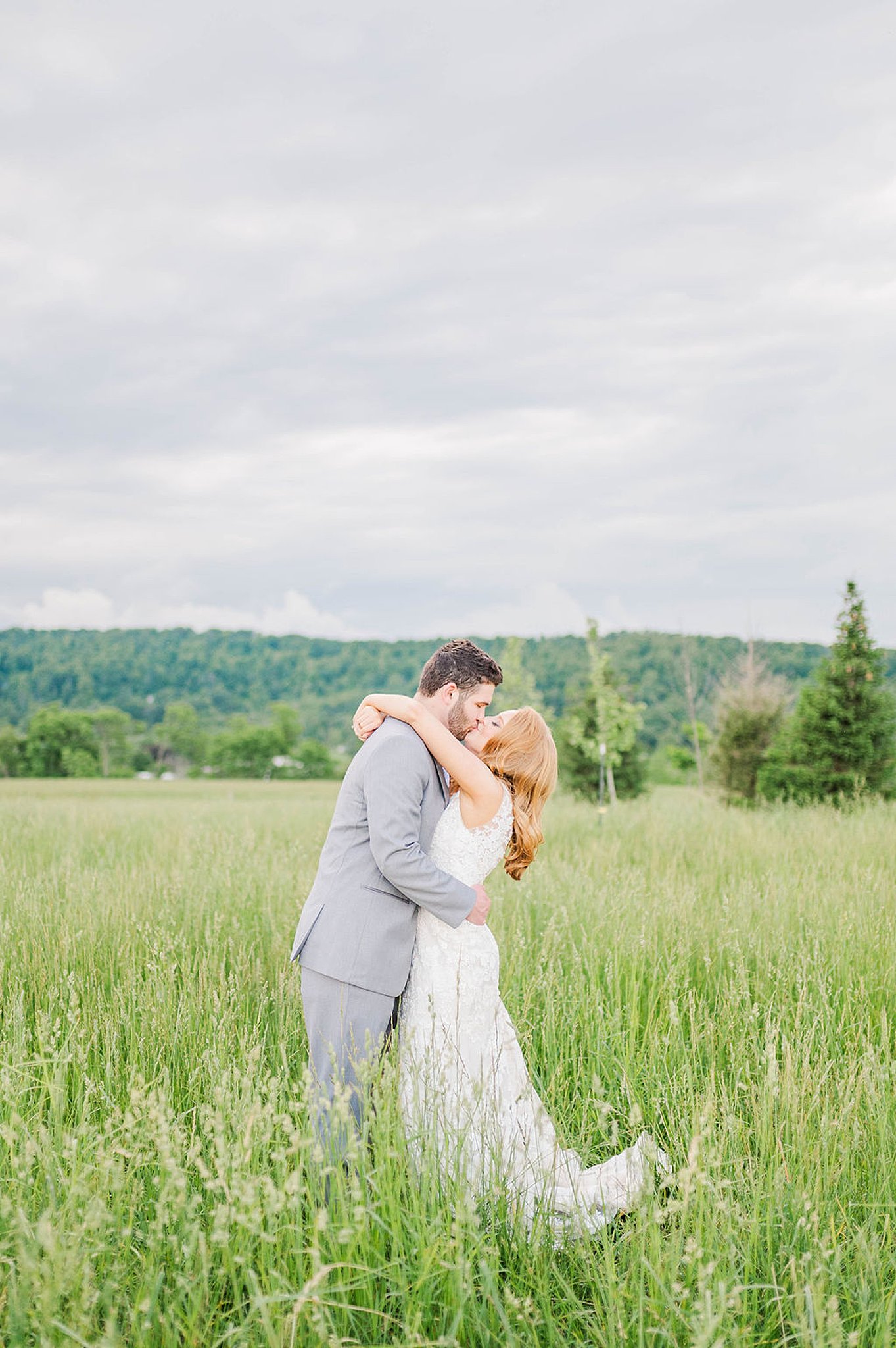 bride and groom kiss in the middle of a large field with tall grass Richmond Weddings
