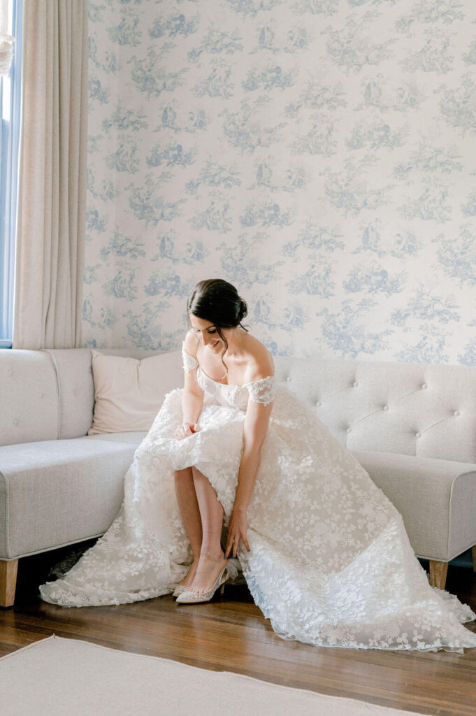 Bride putting on her wedding shoes at Rust Manor House