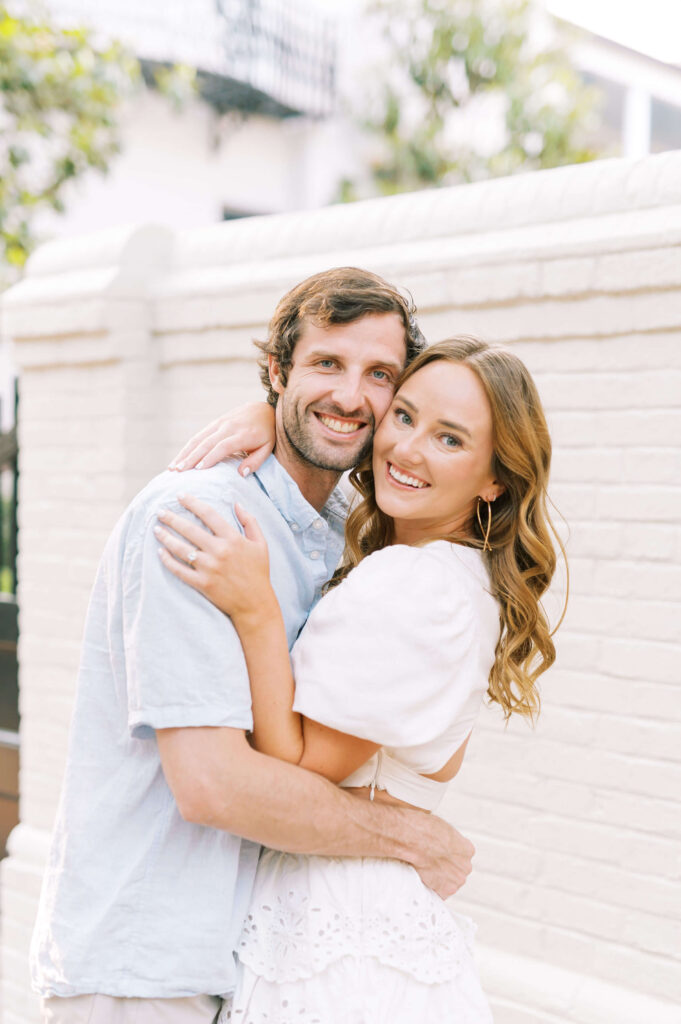 Couple smiling cheek to cheek for engagement photos. 
