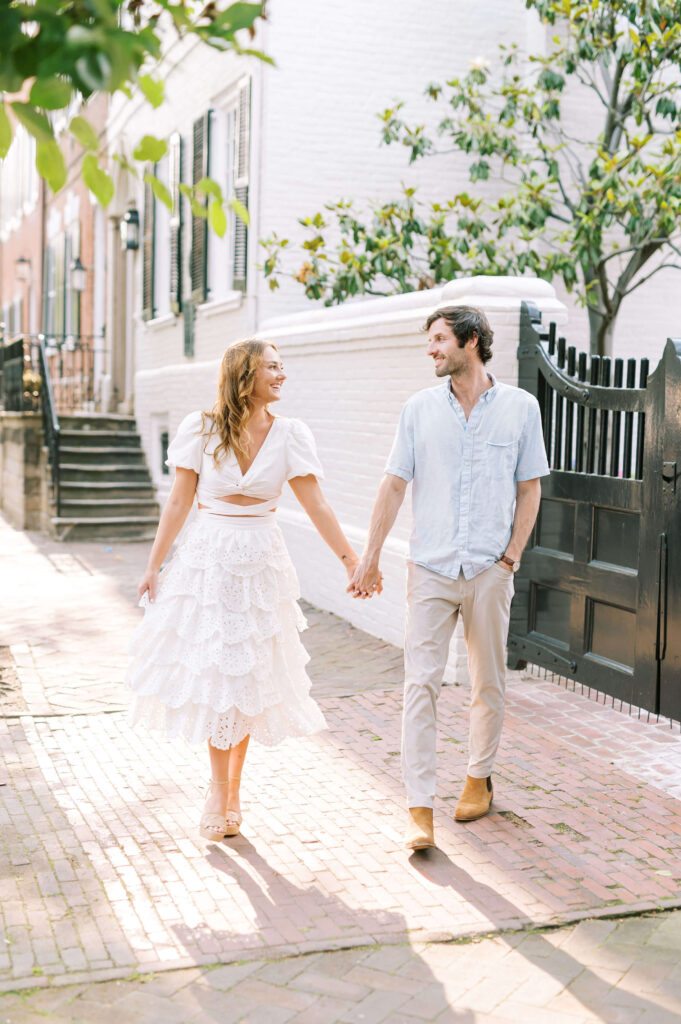Couple walking down Old Town Alexandria streets for engagement photos
