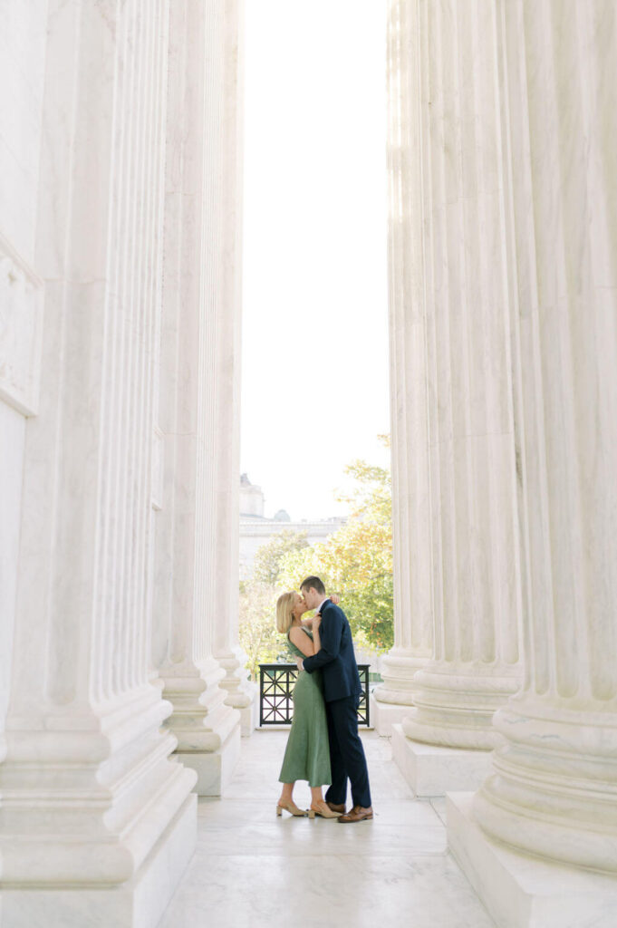 Couple kissing between columns in DC
