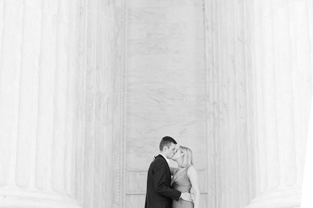 Couple kissing passionately in front of the columns at the U.S. Supreme Court. 