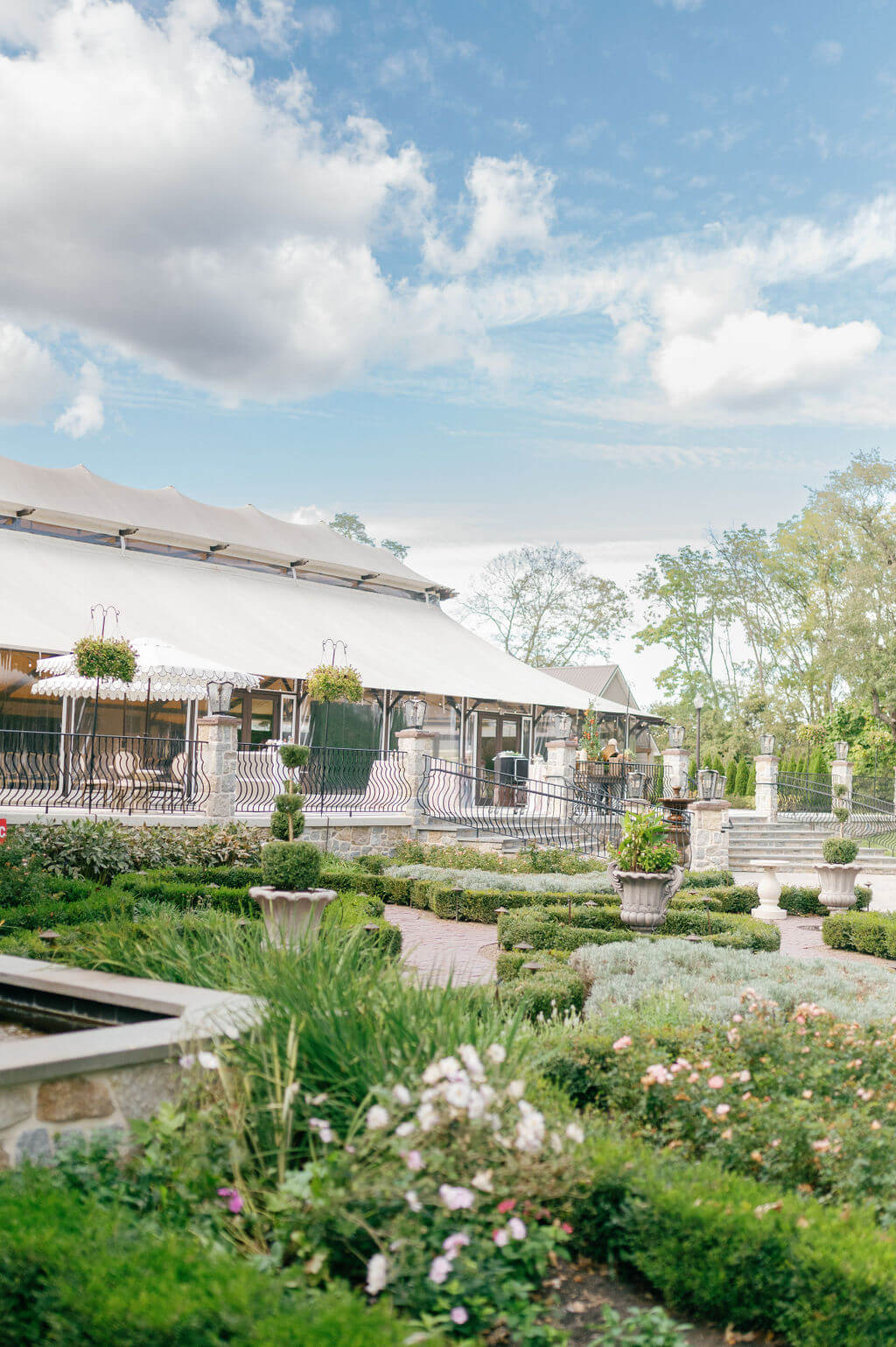 Garden and exterior view of the main event tent at The Willows at Ashcombe Mansion on a sunny wedding day.