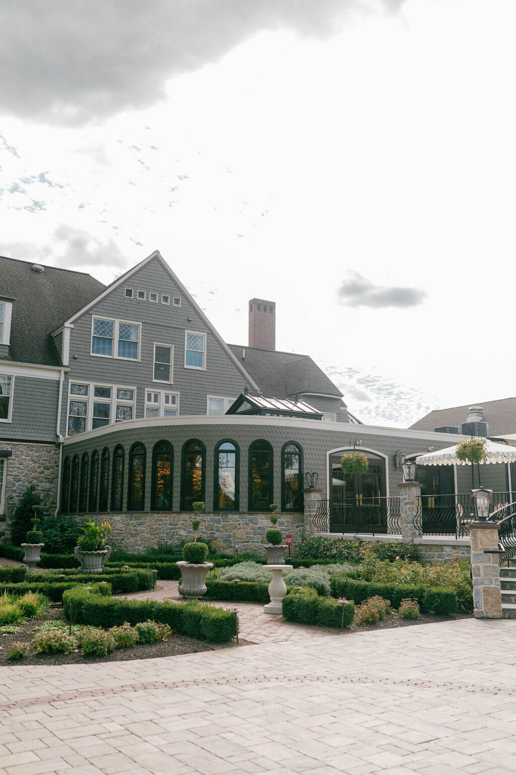Rear view of The Willows at Ashcombe Mansion showcasing its historic architecture and garden pathways.
