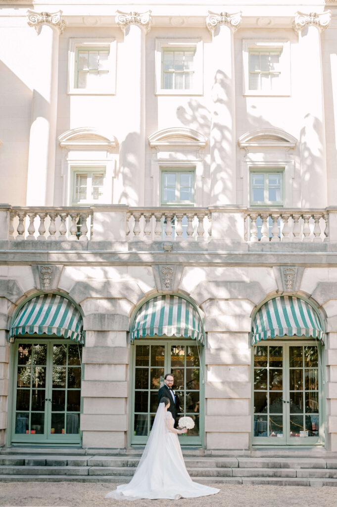 Bride and groom kissing in front of Larz Anderson House